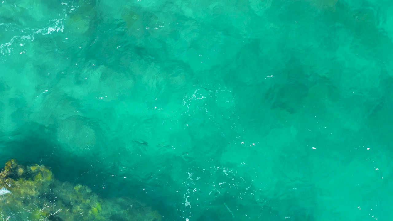 Turquoise ocean water over submerged rocks