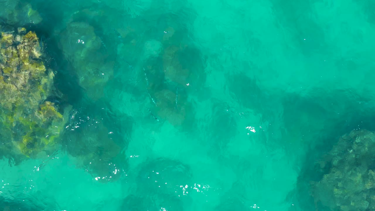 Clear water with rocks along the left edge