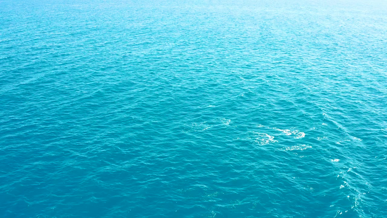 Overhead view of blue ocean in East Cape, Baja California Sur, with faint white foam streaks toward the right side and no visible people.