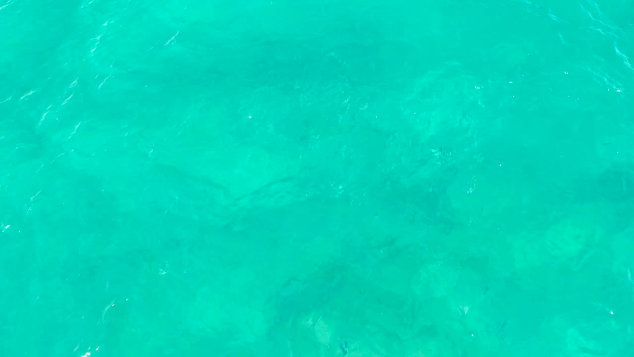 Turquoise water surface with brighter reflected highlights
