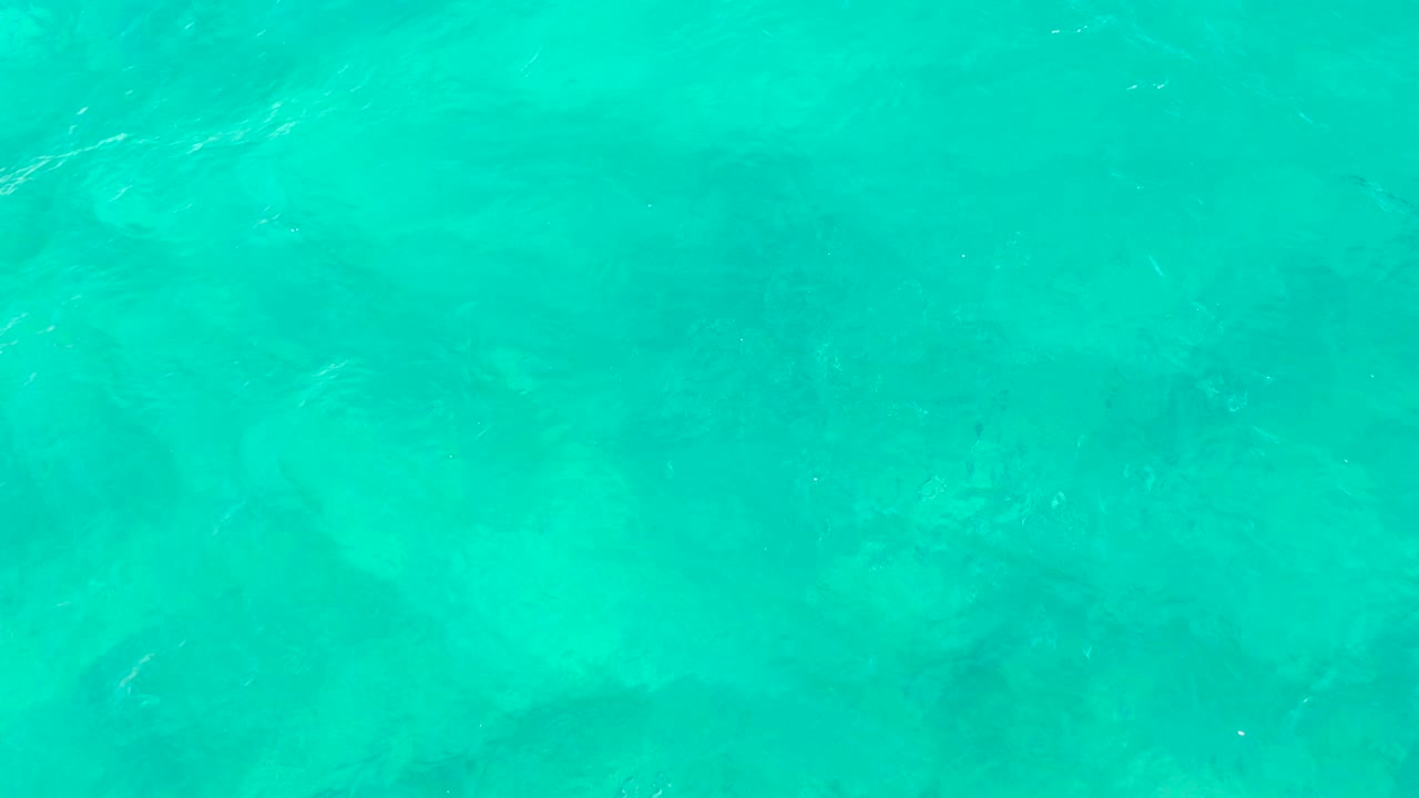 Turquoise ocean surface with faint seabed detail