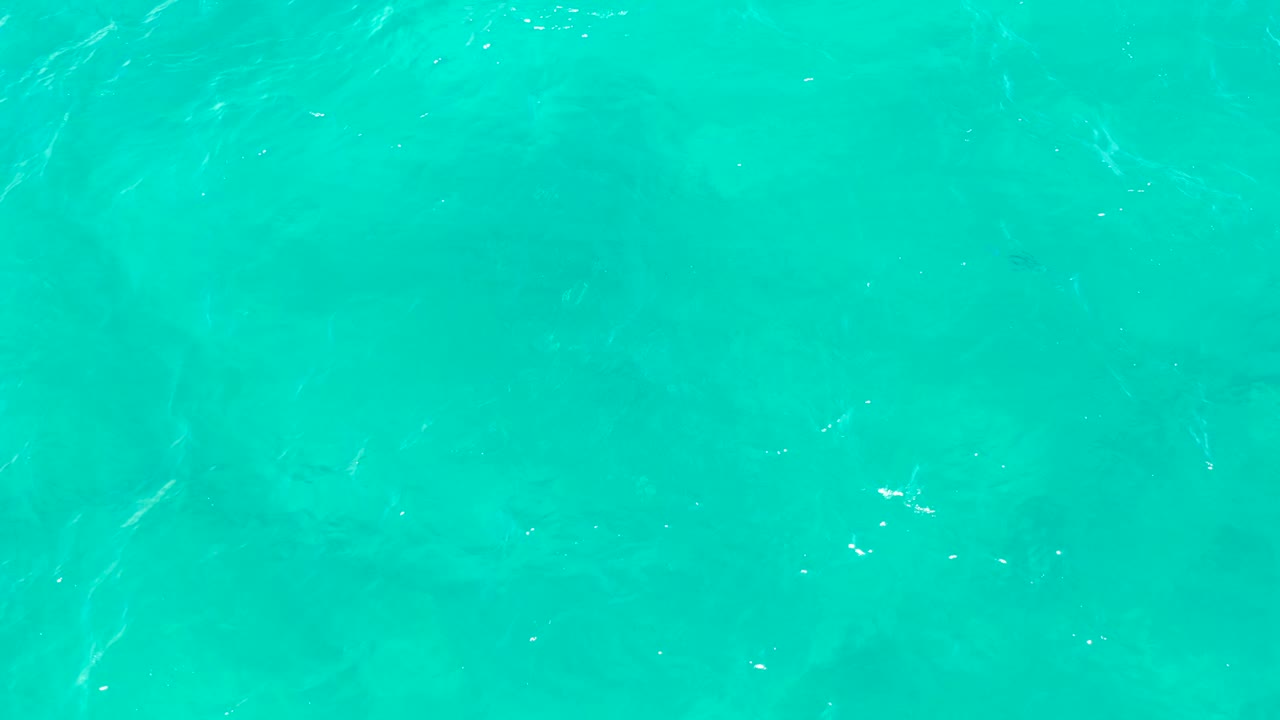 Clear East Cape turquoise water with small ripples crossing the surface, subtle sunlight flecks, and no visible people or objects.