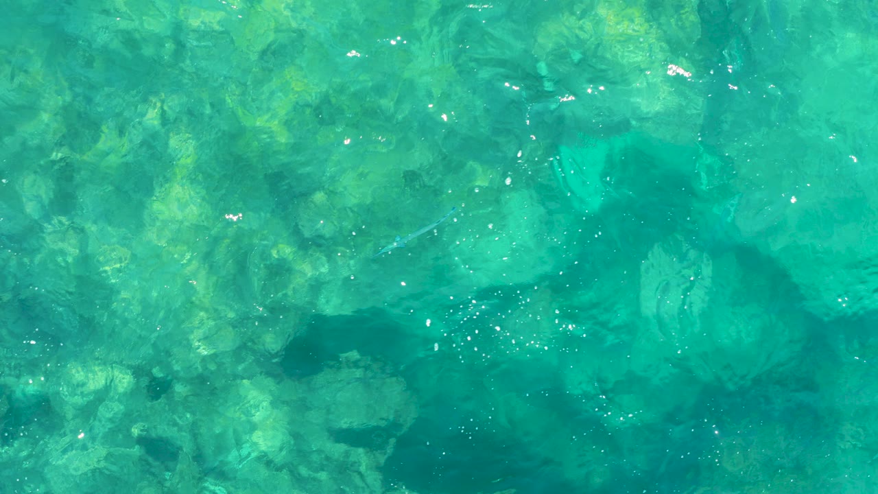 Turquoise shallow water over submerged rocks
