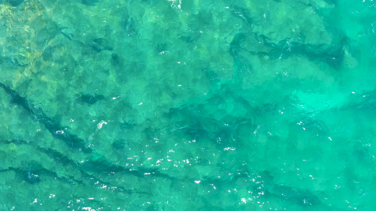 Shallow turquoise water with softened rock shapes
