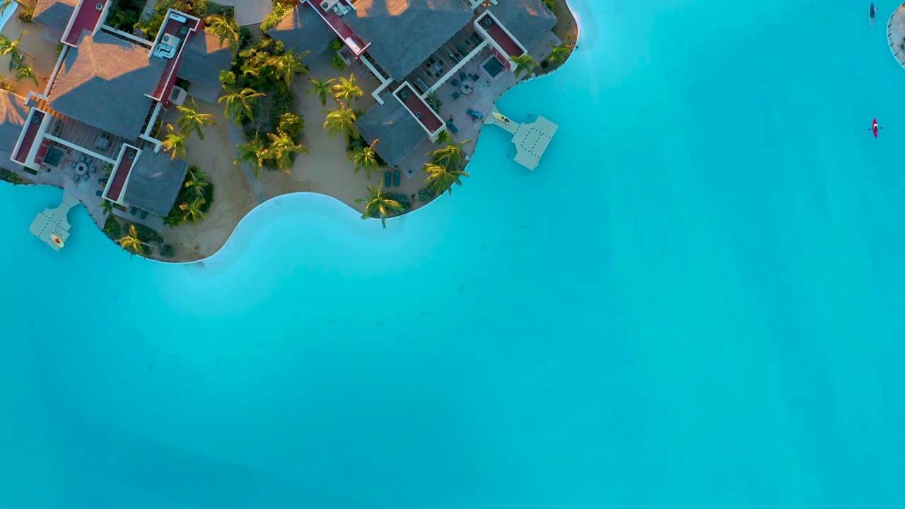 Aerial view of resort grounds and curved blue shoreline.