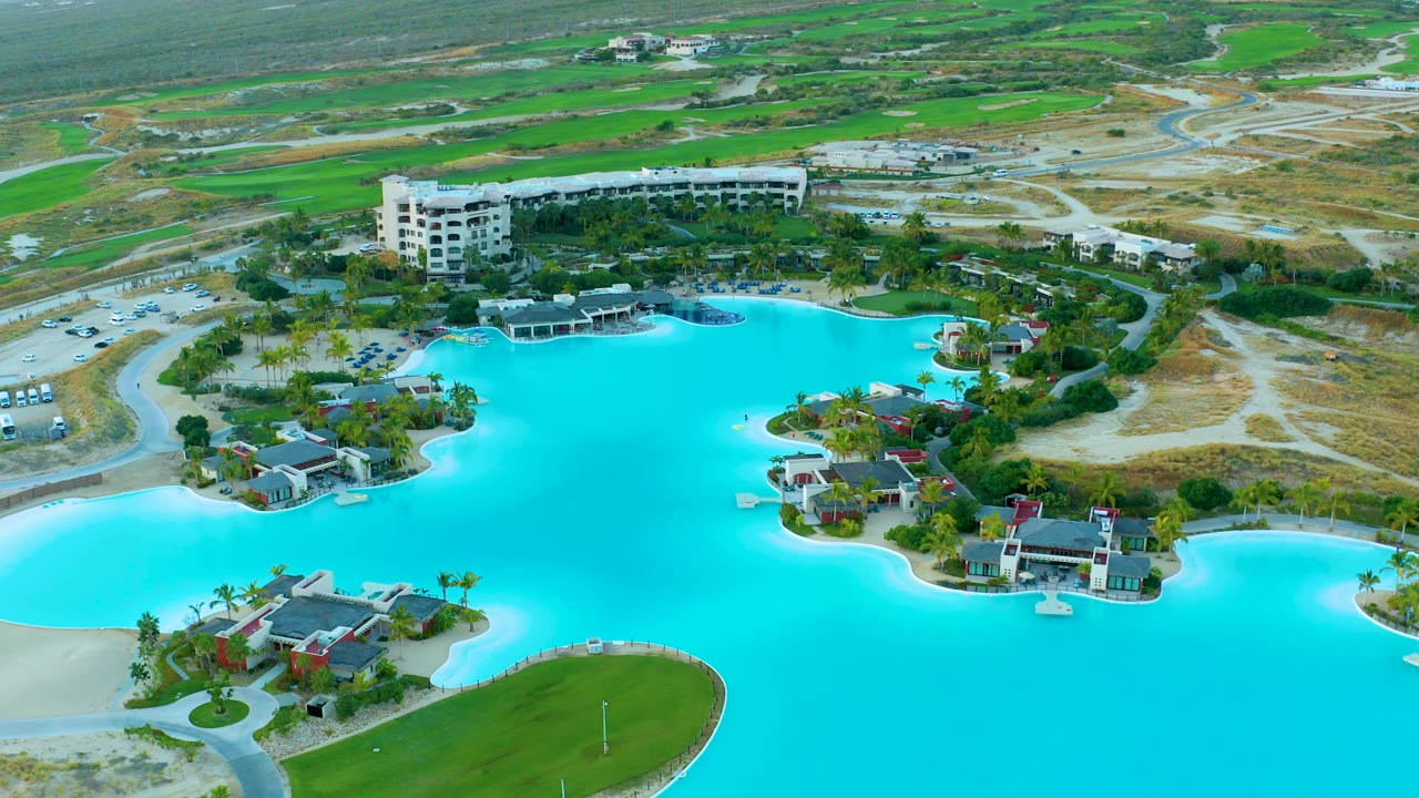 Overhead resort lagoon with villas and golf course in the distance.