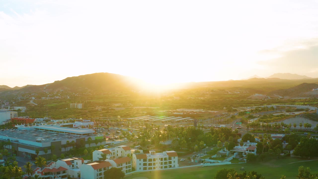 Aerial city view with low sun and green lens flare