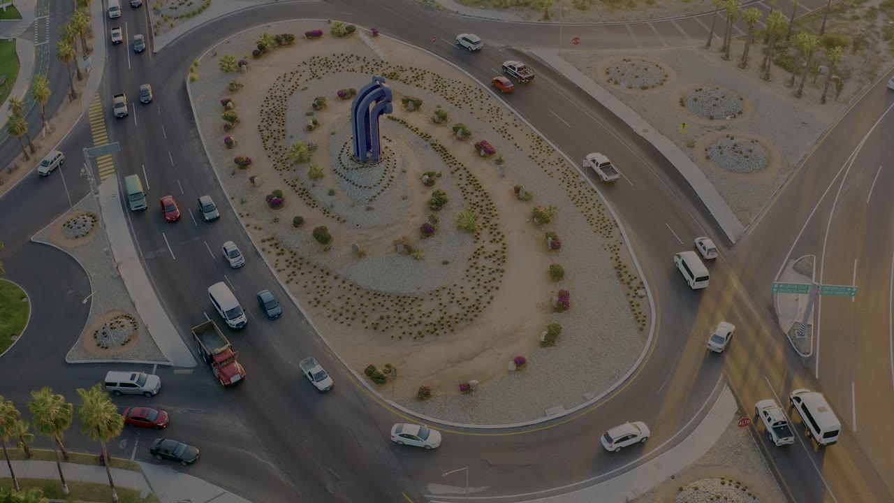 Vehicles circulate around a landscaped traffic circle.