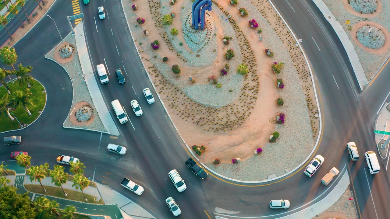 Vehicles circulate beside the central island of a roundabout.