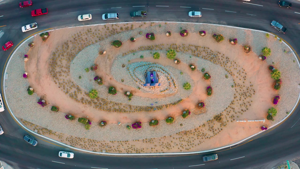Overhead roundabout scene with cars passing the landscaped island.