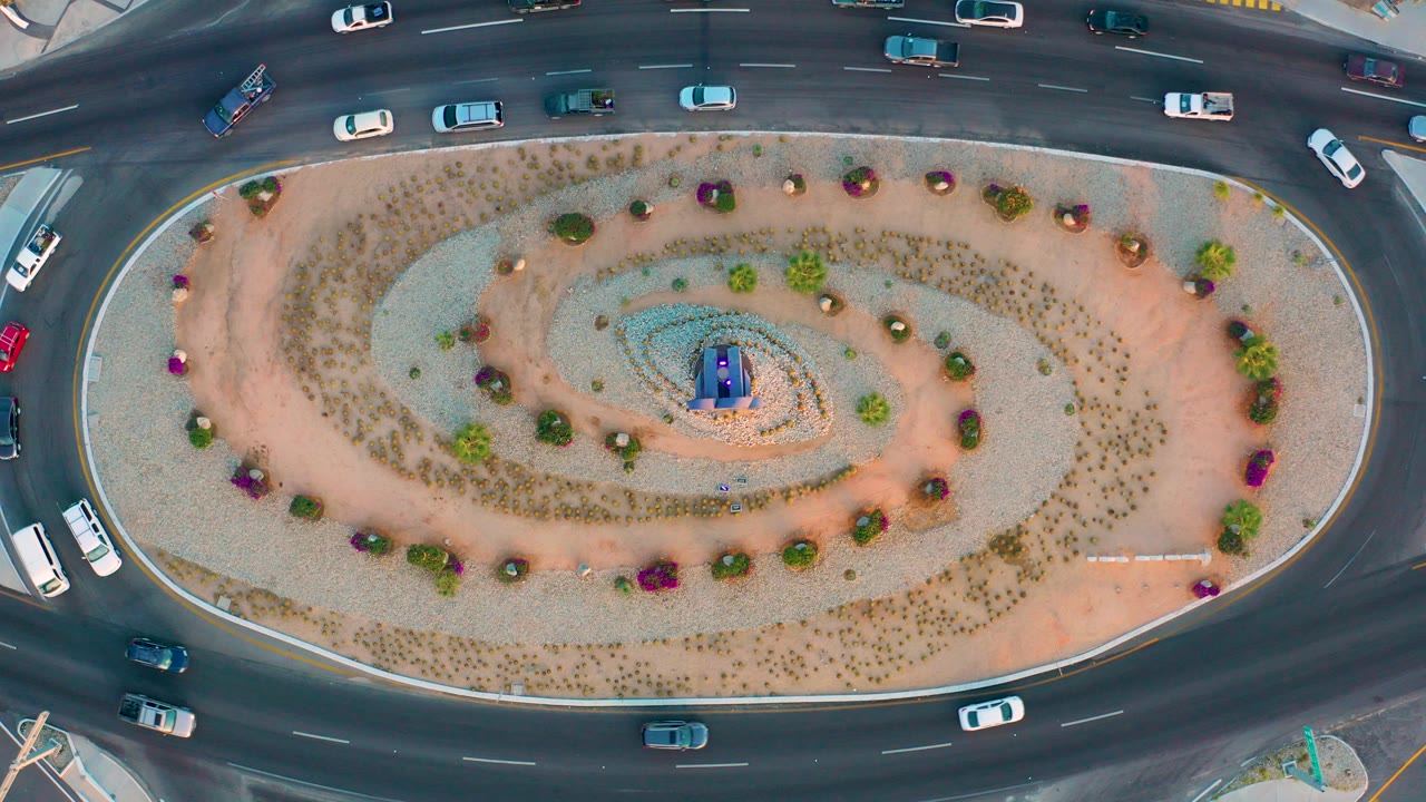 Overhead view of cars circling a landscaped roundabout