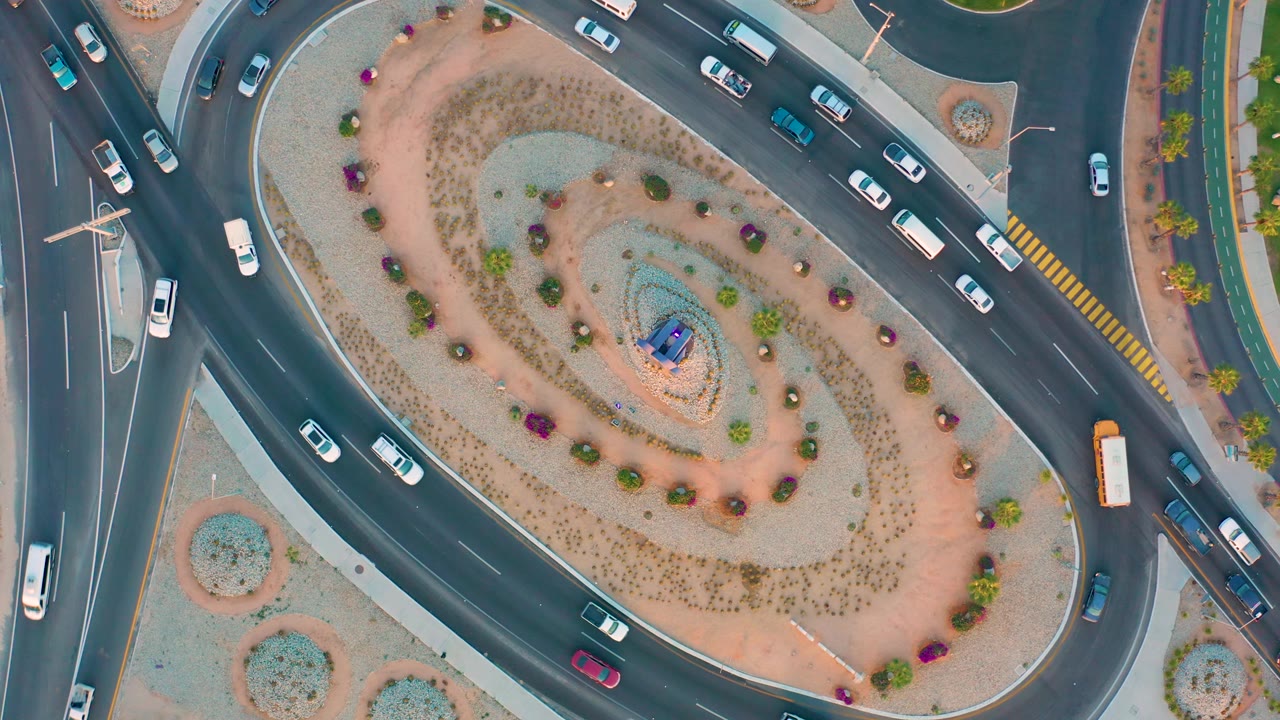 Aerial roundabout view with vehicles on intersecting roads.