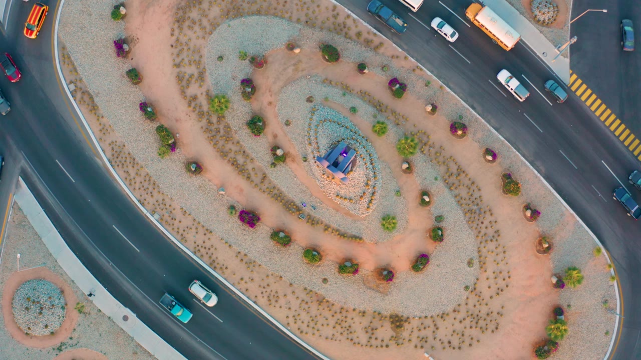 Aerial road curve beside planted roundabout island