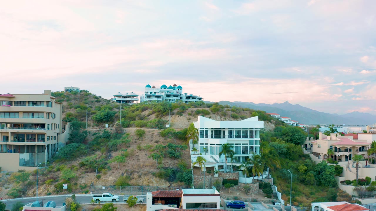 Hillside buildings above foreground road and rooftops