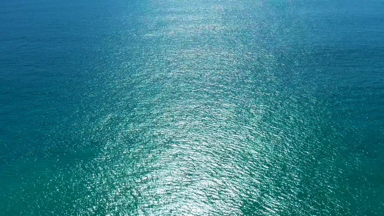 Ocean surface filled with ripples and sun sparkle.