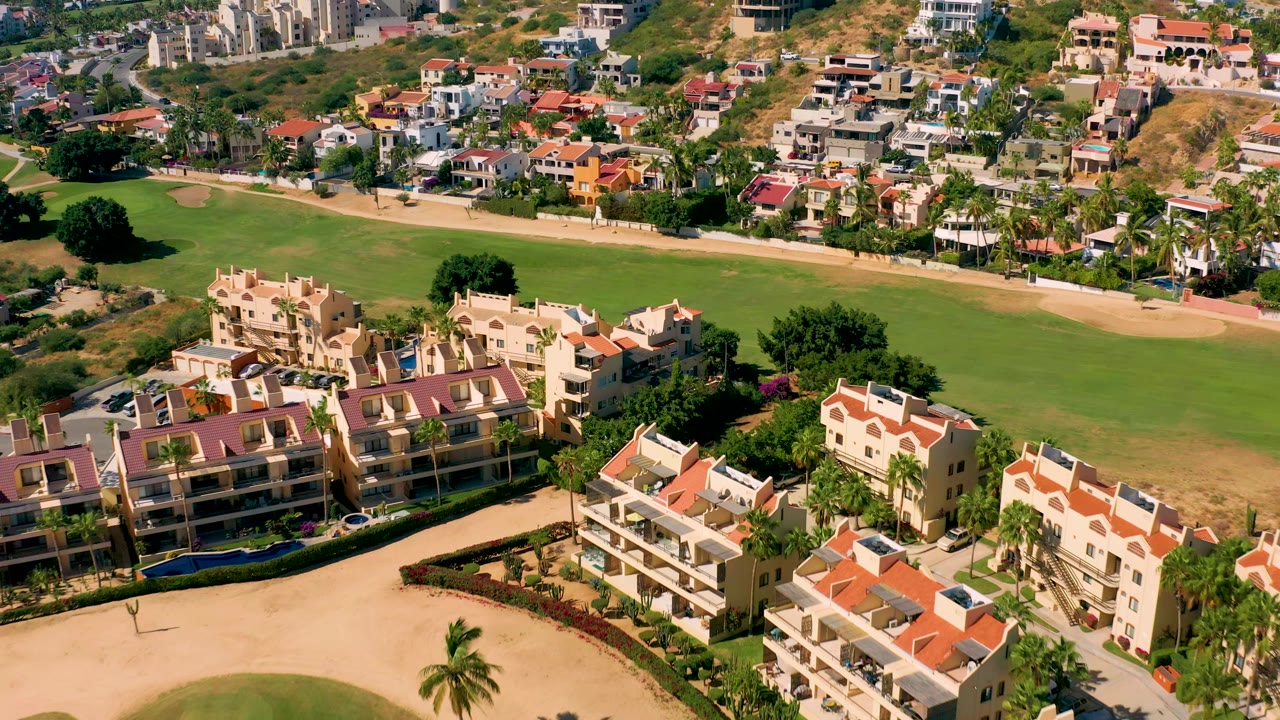 Drone view of apartment buildings and golf course fairway.