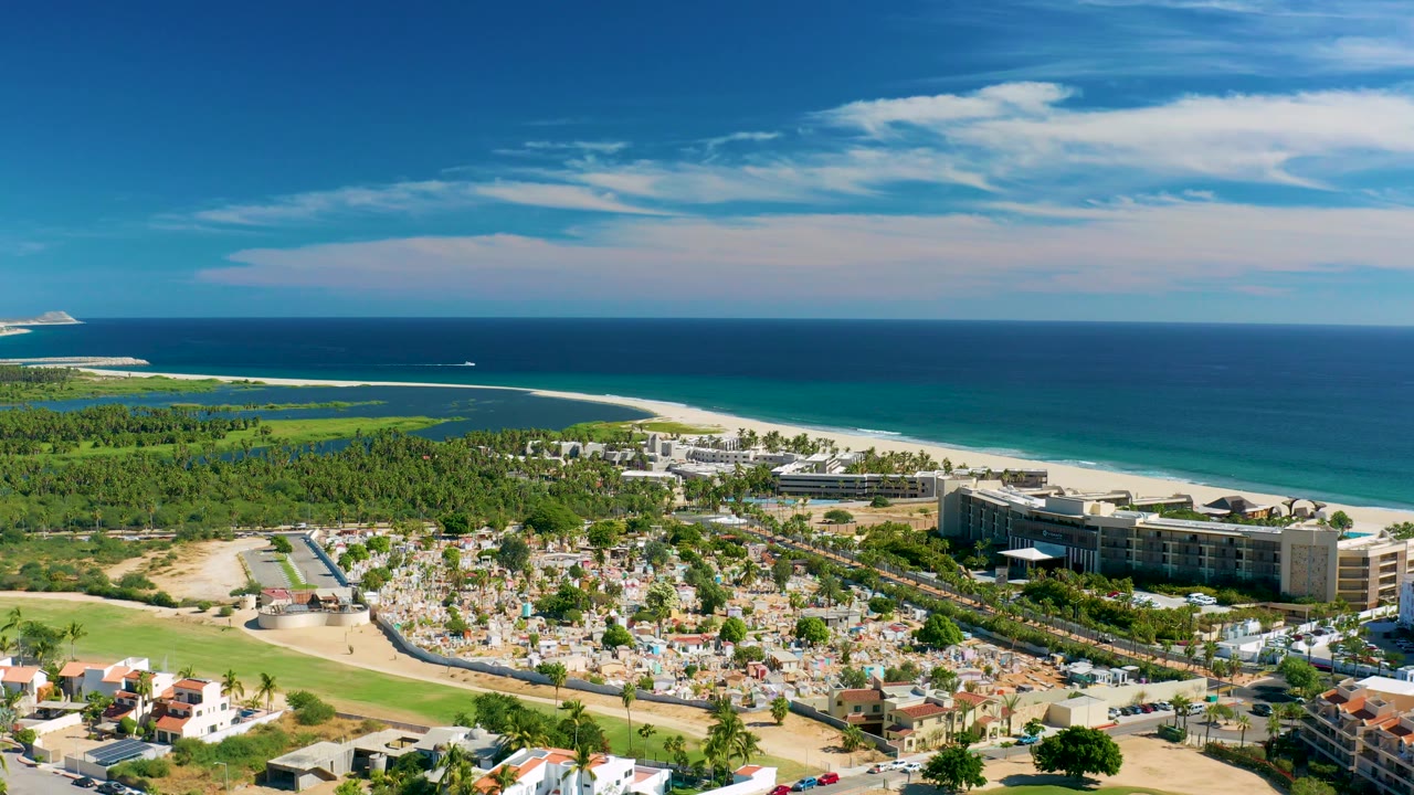 High aerial view of resort area, beach, ocean, golf course, and neighborhood roads.
