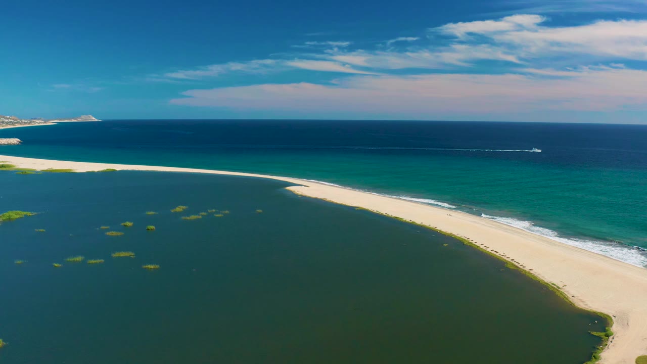 Curved beach separating green lagoon from blue ocean