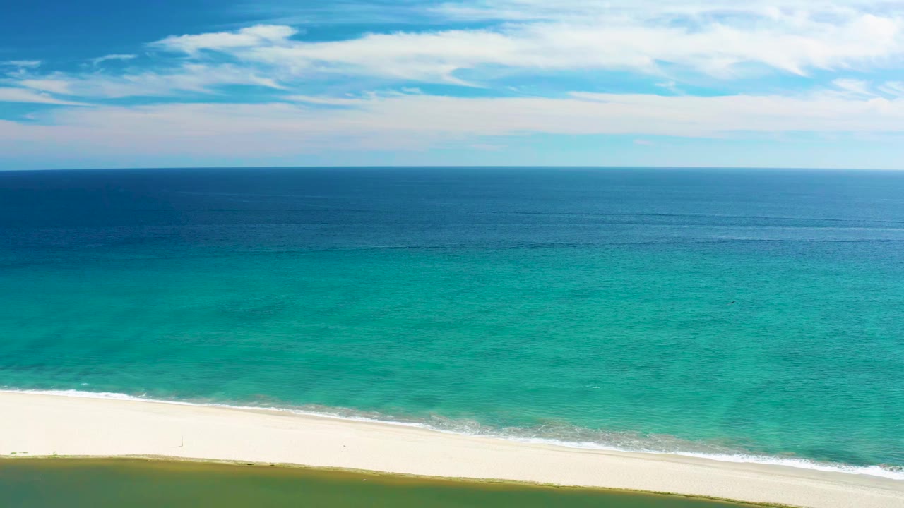 San Jose Del Cabo aerial view with the ocean occupying most of the frame, the white beach slightly lower in view, a thin surf line, and no visible people.