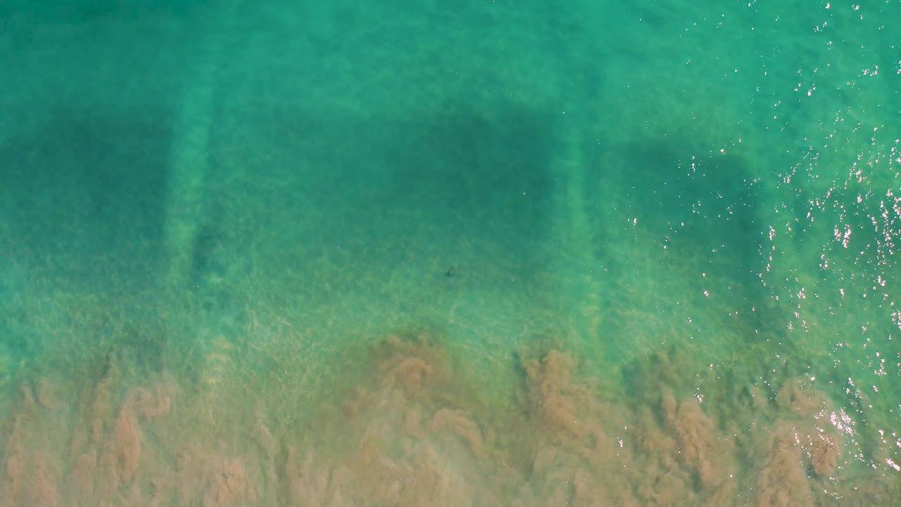 Turquoise water with sandy seabed and light patterns