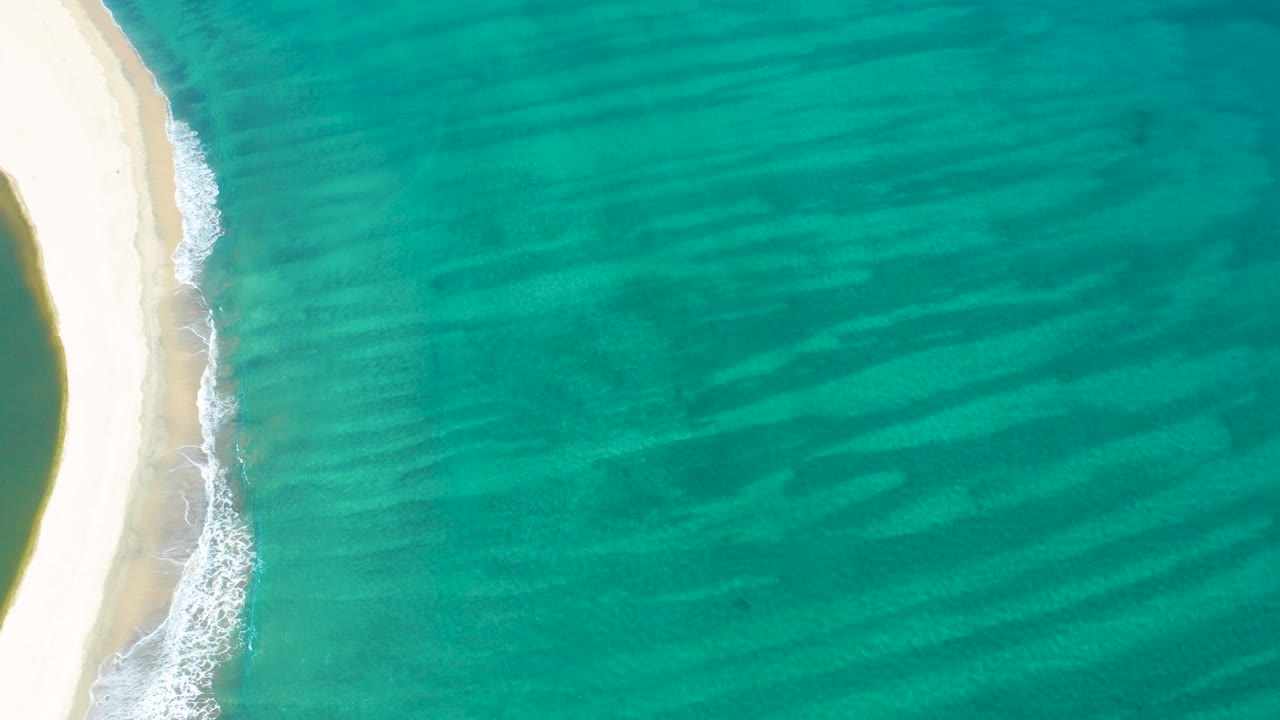 Overhead beach edge with turquoise ocean and white surf