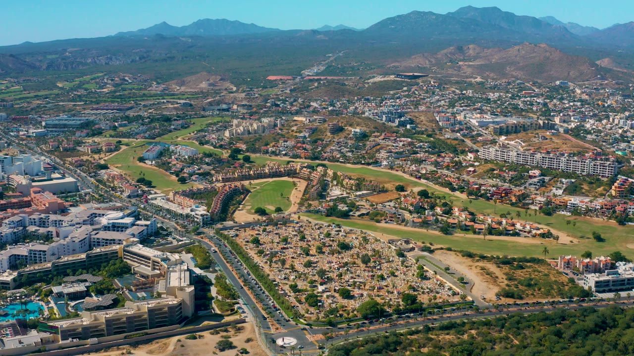 Residential aerial with golf greens in the midground and mountains behind.