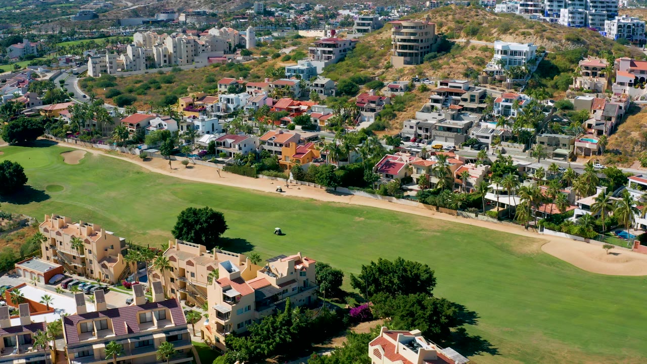 Aerial view of a fairway, cart path, and neighborhood homes.