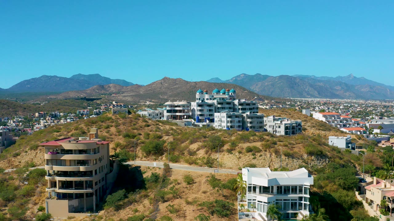 Hillside road and residential buildings with mountain horizon