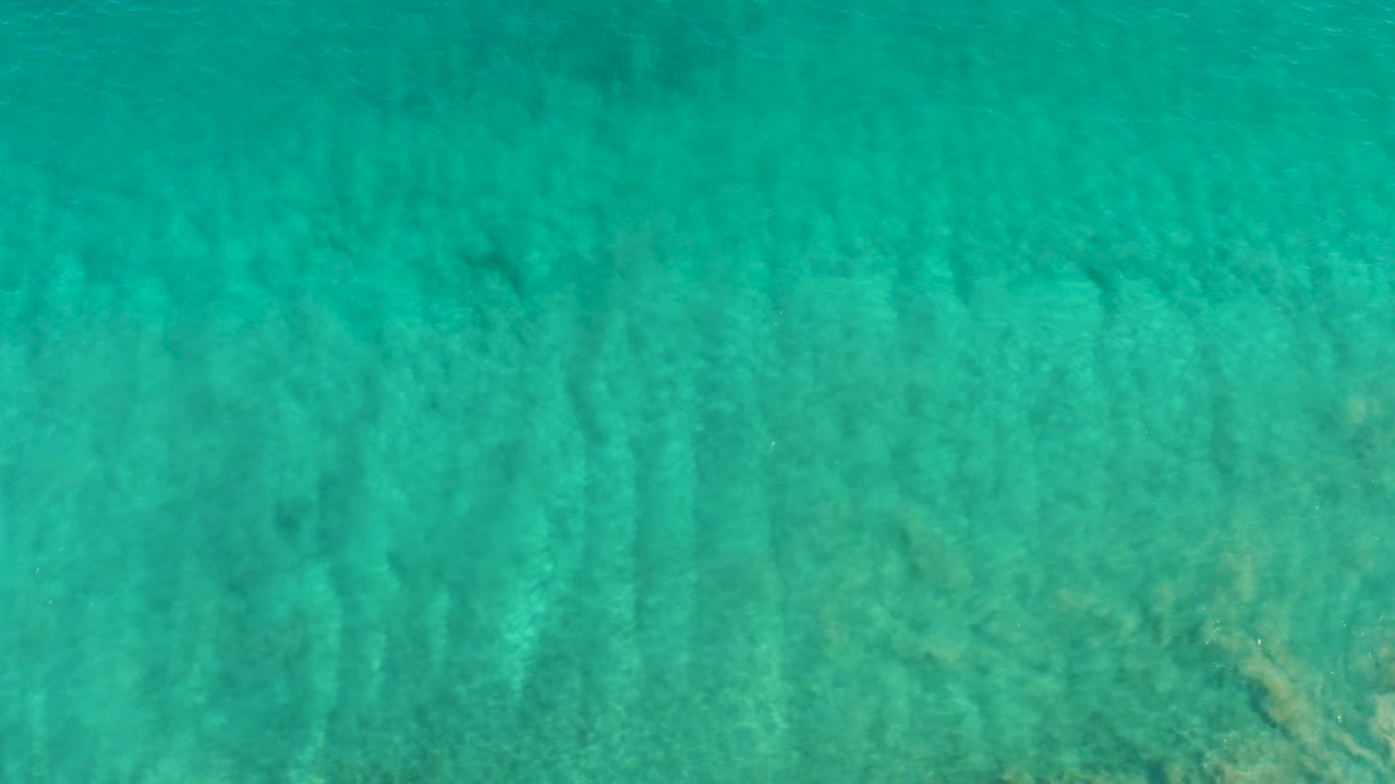Turquoise shallow ocean water over sandy bottom