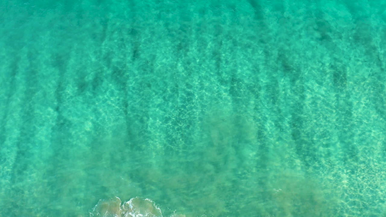 Overhead view of clear turquoise ocean water in San Jose Del Cabo, Mexico, with rippled light over the seabed and no visible people.