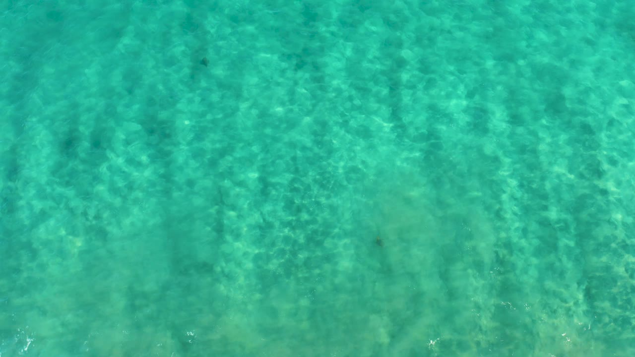 Transparent turquoise ocean water in San Jose del Cabo shows a shallow seabed through the surface pattern, with no visible people.