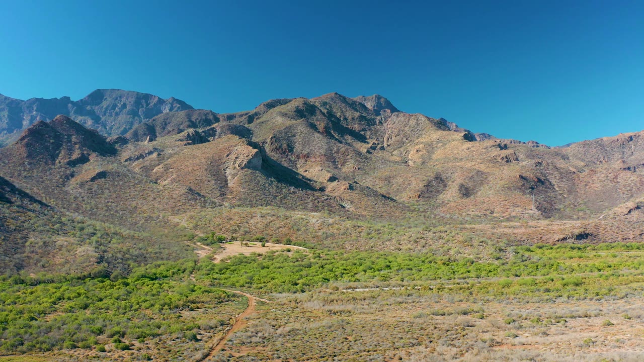 Rocky hills and green valley vegetation viewed from above.