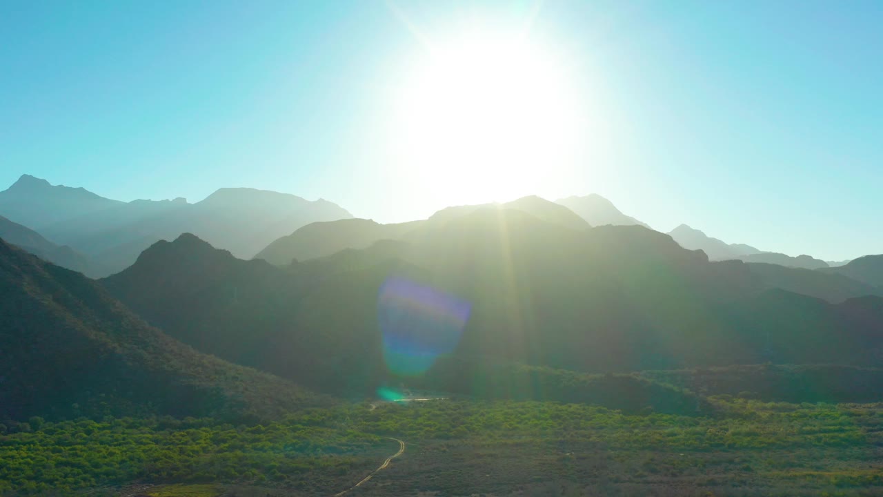 Mountain valley with road and strong sun glare
