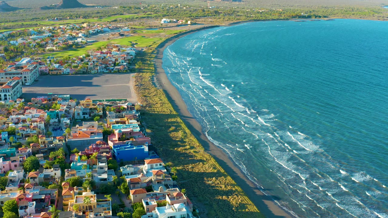Aerial frame of beachside neighborhood and ocean waves