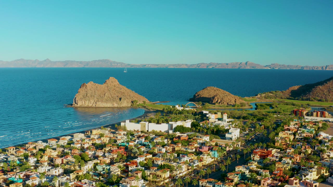 Aerial shoreline view with town foreground and rocky outcrop in the water