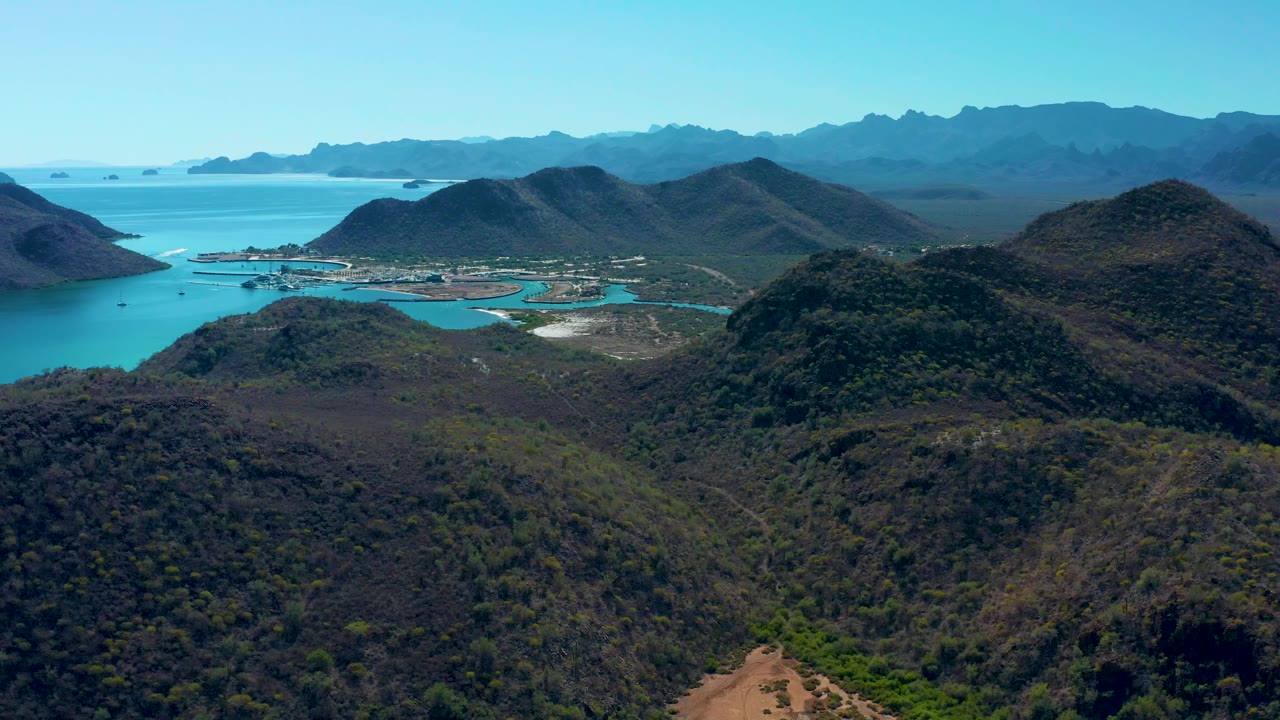 Wide aerial of coastal hills and exposed shoreline