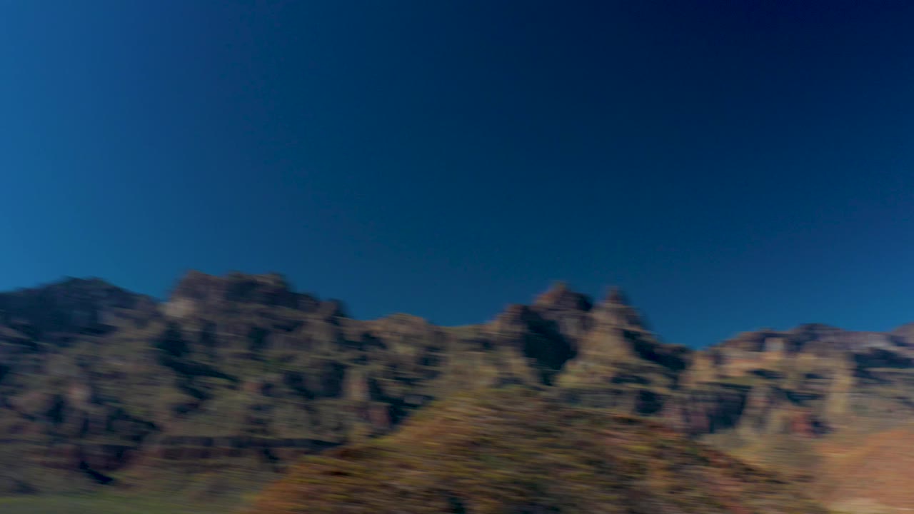 Motion-blurred view of rugged mountains near Juncalito, Baja California Sur, with a deep blue sky and no visible people.
