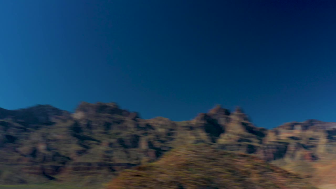 Blurred rocky peaks and earthy slopes near Juncalito, Baja California Sur, with the sky occupying the upper frame and no visible people.