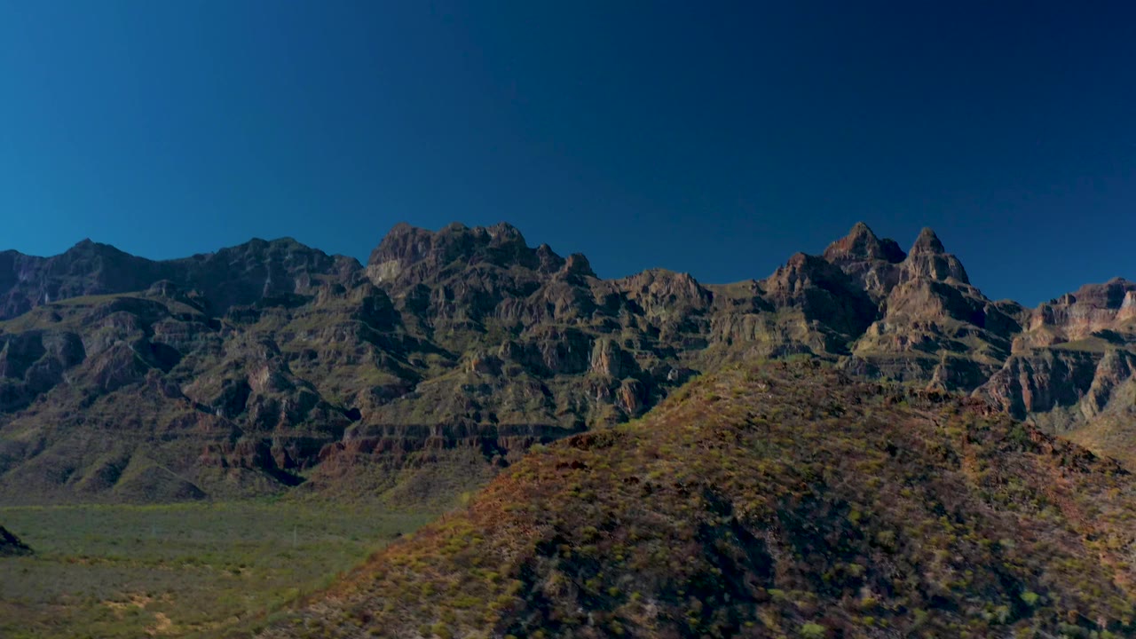 Layered mountain range and foreground desert hill