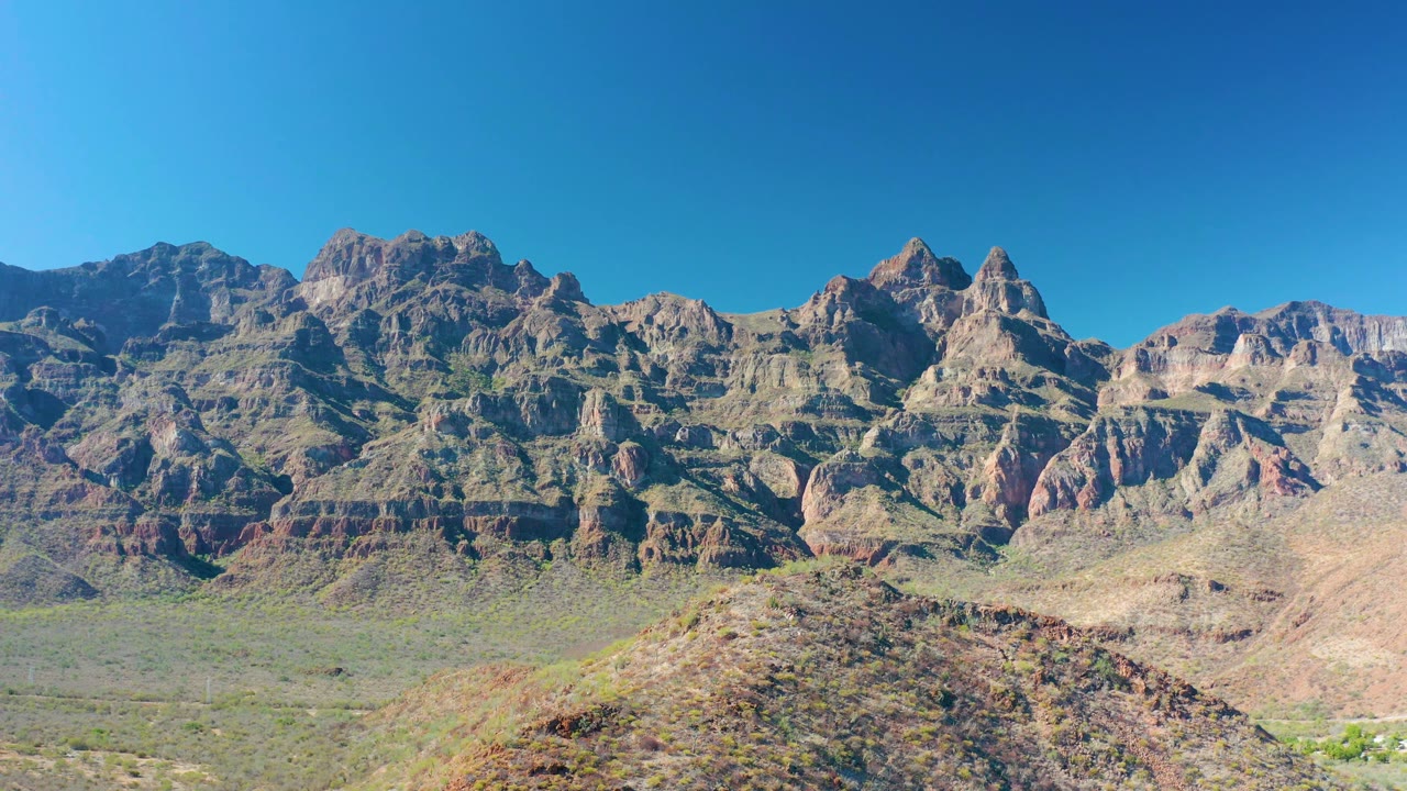Stratified mountain face with desert valley foreground