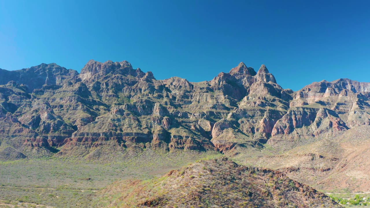 Layered rocky peaks behind a dry valley.