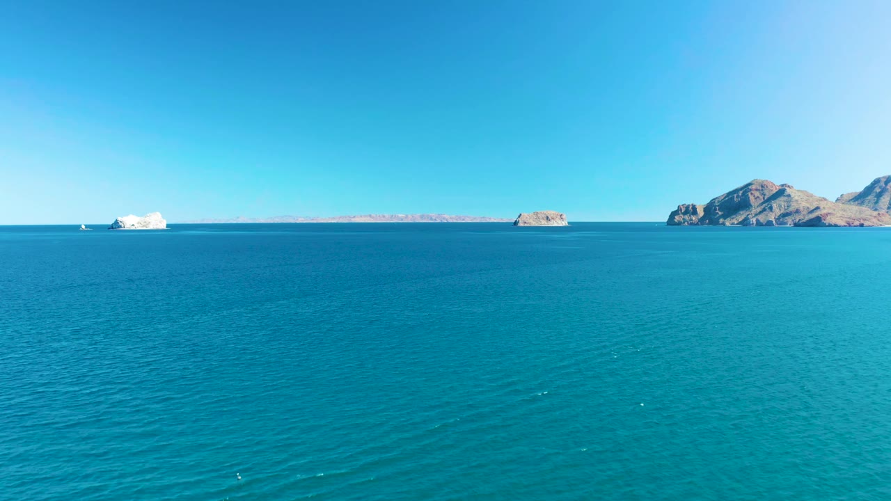 One second in, the Ligui ocean view holds a level horizon, with rippled turquoise water in front, low rocky islands in the distance, and no visible people.