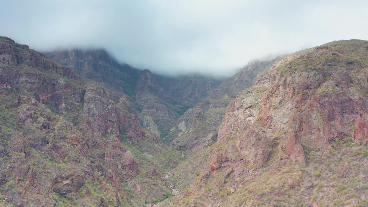 Mountain valley partly hidden by low cloud.