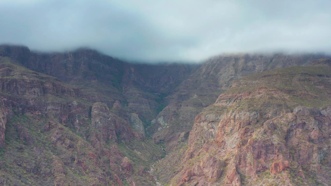 Rocky mountain valley under low clouds
