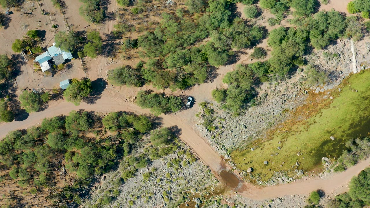 Rural house and car above a flooded dirt crossing