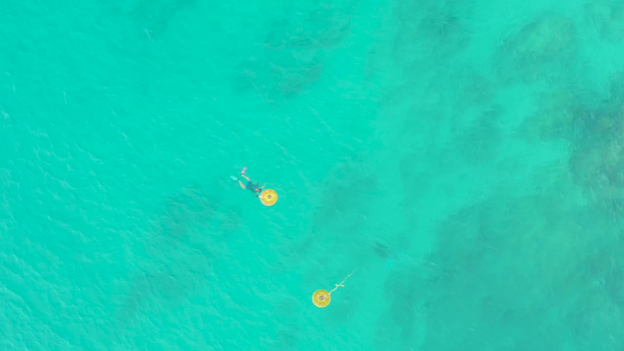 At 0:01, the person and yellow float sit slightly right of the previous position within clear blue-green water at Laguna Beach Los Cabos.