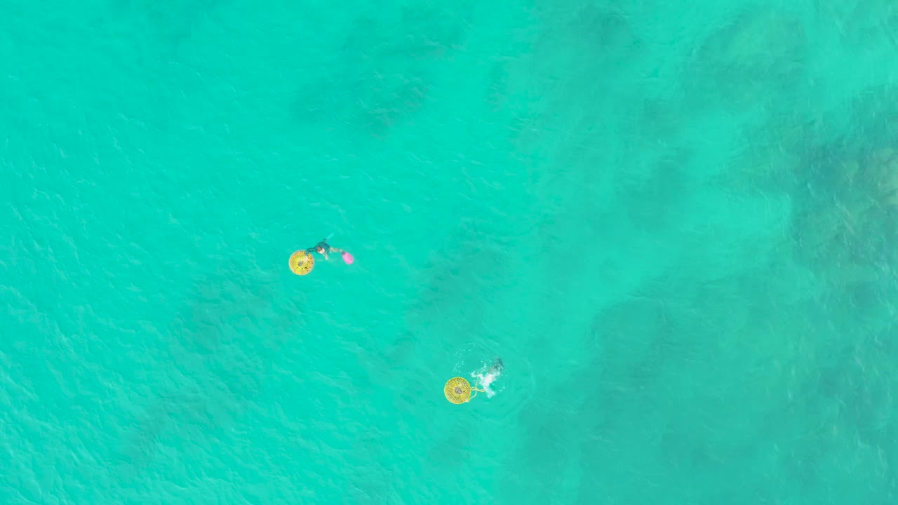 Two small floating figures on yellow rings seen from directly above.