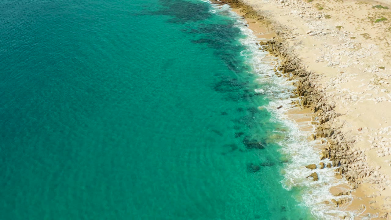 Diagonal shore with small waves and shallow water.