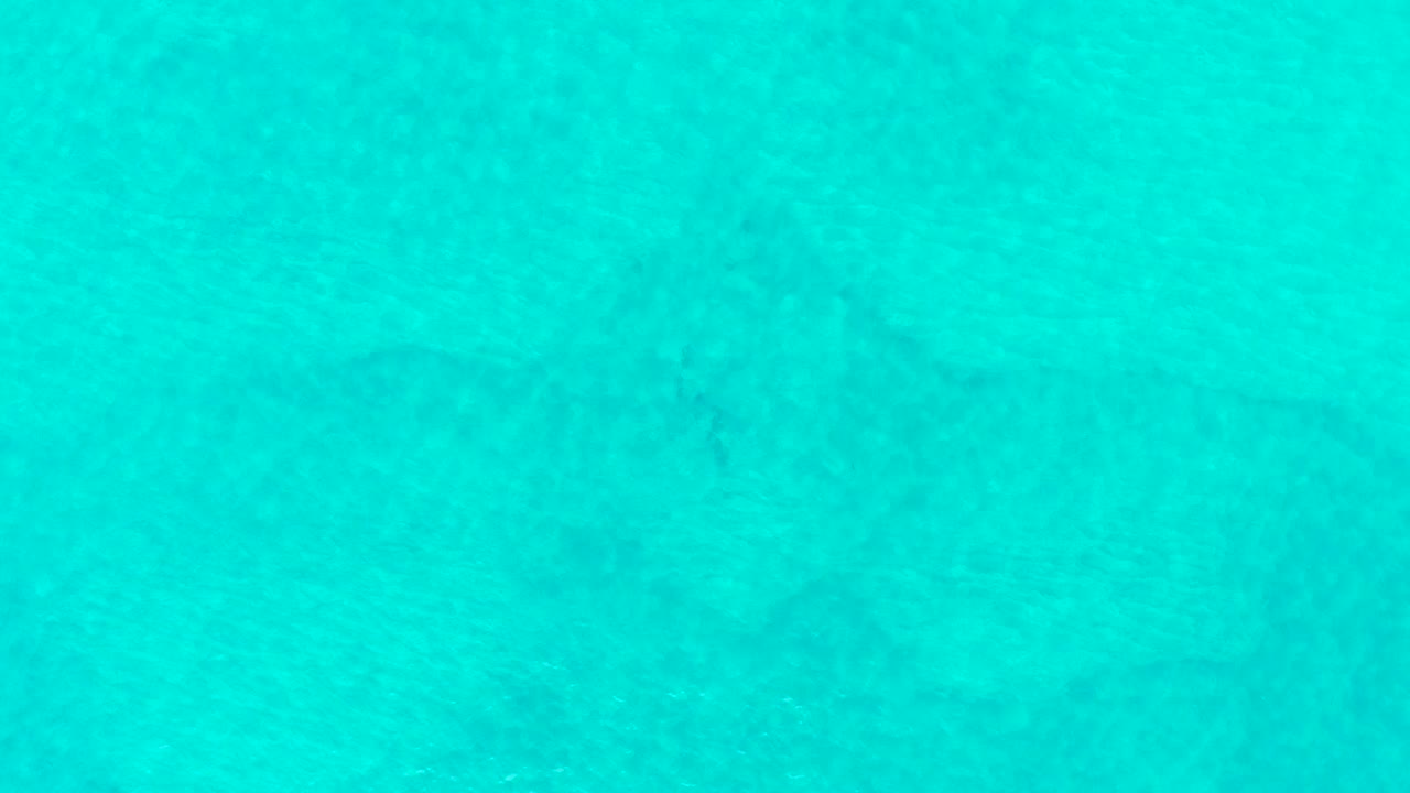 Turquoise shallow ocean water with faint seabed texture.
