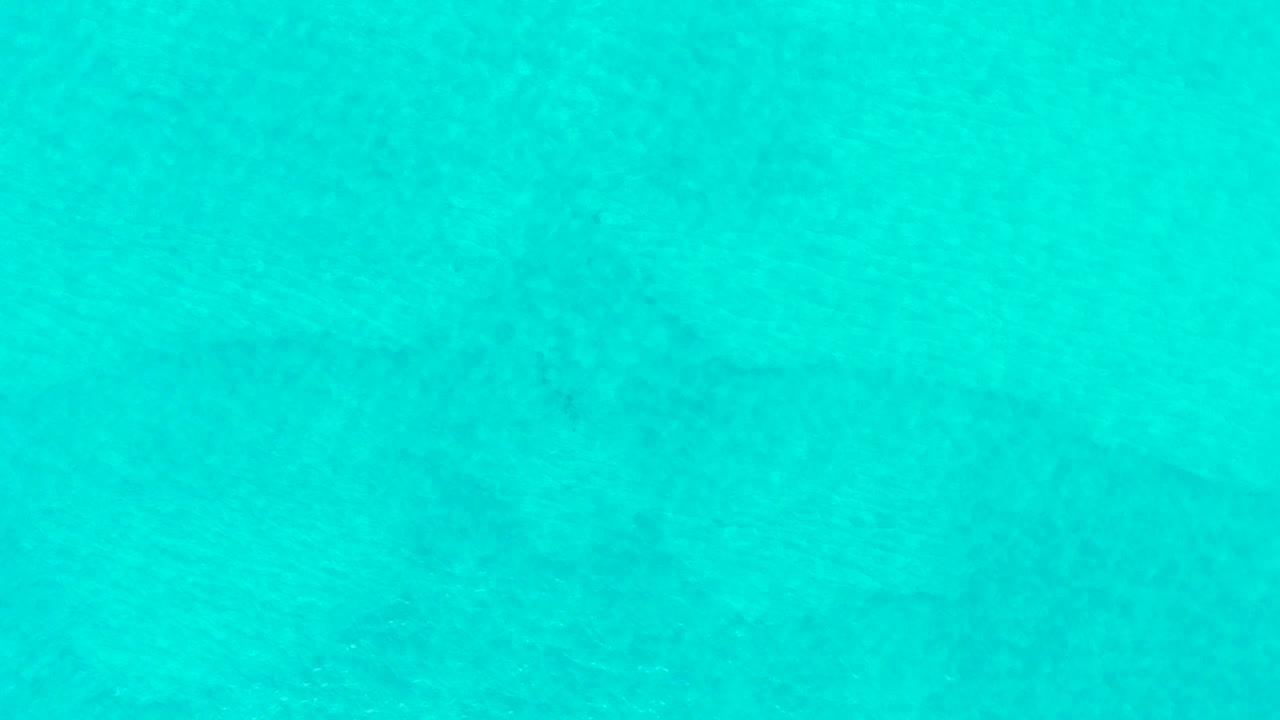 Even turquoise ocean field with faint seabed detail.